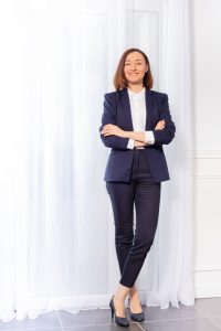 Woman in trouser suit standing with arms crossed